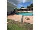Backyard pool area with brick patio, landscaping, and lounge chairs at 3012 Grand View Ave, Clearwater, FL 33759