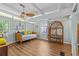 Bright sun room with vaulted ceilings, wood laminate flooring, modern ceiling fan, and built-in shelf at 3012 Grand View Ave, Clearwater, FL 33759