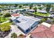 Aerial view of a home with a canal front backyard, featuring a brick driveway and lush surrounding greenery at 304 Westwinds Dr, Palm Harbor, FL 34683