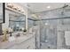 Modern bathroom features marble walk-in shower, a quartz vanity and elegant lighting at 304 Westwinds Dr, Palm Harbor, FL 34683
