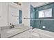 Updated bathroom with blue tiled shower and white vanity at 304 Westwinds Dr, Palm Harbor, FL 34683
