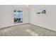 Bright bedroom features neutral carpeting and a view to the outdoor patio at 304 Westwinds Dr, Palm Harbor, FL 34683