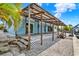 Home's rear exterior with a large covered porch and white rock yard at 304 Westwinds Dr, Palm Harbor, FL 34683