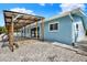 Rear exterior view of home with a covered patio and gravel yard at 304 Westwinds Dr, Palm Harbor, FL 34683