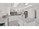 Bright modern kitchen features white cabinets, a center island, and views into the living area at 304 Westwinds Dr, Palm Harbor, FL 34683