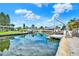 Picturesque waterfront view showcasing a canal with a boat lift, docks, and lush green landscaping under a bright sky at 304 Westwinds Dr, Palm Harbor, FL 34683