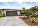 Inviting home showcasing lush landscaping, a well-maintained lawn, and a 2-car garage at 309 Palmetto Ln, Largo, FL 33770