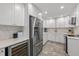 Modern white kitchen with stainless steel appliances and white marble countertops at 309 Palmetto Ln, Largo, FL 33770