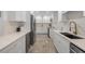 Bright kitchen features white cabinets, modern appliances, and stone tile flooring at 309 Palmetto Ln, Largo, FL 33770
