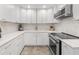 Kitchen with modern appliances, white cabinets, and white marble backsplash at 309 Palmetto Ln, Largo, FL 33770