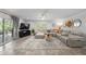 Open living room with comfortable sectional sofa, area rug, and sliding glass doors at 309 Palmetto Ln, Largo, FL 33770