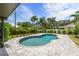 This backyard features a kidney-bean-shaped pool with mature tropical landscaping at 309 Palmetto Ln, Largo, FL 33770