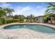 Backyard oasis featuring a kidney-shaped pool, with a paver deck and outdoor dining area at 309 Palmetto Ln, Largo, FL 33770
