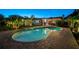 Stunning backyard pool at twilight with paver deck and covered patio for entertaining at 309 Palmetto Ln, Largo, FL 33770