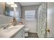 Charming bathroom featuring neutral tile, floral shower curtain, and white vanity at 3111 W Douglas St, Tampa, FL 33607