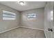 Neutral bedroom with plush carpet, two windows, and a ceiling light at 3111 W Douglas St, Tampa, FL 33607