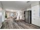 Open-concept living and dining area with updated flooring and stainless steel refrigerator at 3111 W Douglas St, Tampa, FL 33607