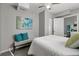 Bright bedroom features modern art, a ceiling fan, and a view to the ensuite bath at 3111 W Douglas St, Tampa, FL 33607