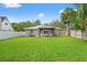 An expansive, green backyard features a covered patio with chairs and outdoor furniture at 3135 W Varn Ave, Tampa, FL 33611