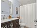 Well-lit bathroom features a vanity with marble countertop and a shower with a white curtain at 3135 W Varn Ave, Tampa, FL 33611