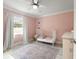 Charming bedroom with light pink walls and a vintage-style white crib at 3135 W Varn Ave, Tampa, FL 33611