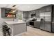 Updated kitchen featuring gray cabinets, stainless steel appliances, quartz countertops, and modern lighting at 3135 W Varn Ave, Tampa, FL 33611