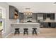 Modern kitchen featuring gray cabinets, stainless steel appliances, and quartz countertops with barstool seating at 3135 W Varn Ave, Tampa, FL 33611