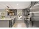 Bright kitchen with stainless steel appliances, gray cabinets, and a view of the neighborhood through the window at 3135 W Varn Ave, Tampa, FL 33611