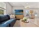 Cozy living area featuring a comfortable blue sofa, accent pillows, and modern entertainment center at 3135 W Varn Ave, Tampa, FL 33611