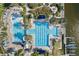 Stunning aerial view of community pool with multiple sections, pool-side lounging, landscaping, and lake access with docks at 315 Blackrock Ln, Apollo Beach, FL 33572
