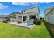 A well-manicured backyard with a paver patio featuring an outdoor kitchen and ample seating at 315 Blackrock Ln, Apollo Beach, FL 33572