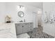 Modern bathroom featuring patterned tile floor, gray vanity with white countertop and stylish round mirror at 315 Blackrock Ln, Apollo Beach, FL 33572