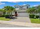 Beautiful two-story home boasts a paved driveway, a two-car garage, and tropical landscaping at 315 Blackrock Ln, Apollo Beach, FL 33572