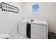 Bright laundry room with side-by-side washer and dryer, accented by decorative laundry sign at 315 Blackrock Ln, Apollo Beach, FL 33572