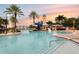 Community pool features lighthouse themed slide, mature palm trees and inviting turquoise water under a colorful sunset at 315 Blackrock Ln, Apollo Beach, FL 33572