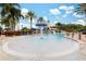 Community pool with a splash pad feature, lighthouse themed slide, lounge chairs, and mature palm trees at 315 Blackrock Ln, Apollo Beach, FL 33572