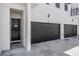 Modern townhome featuring attached garage, a black front door, and exterior lighting at 3210 W Horatio St # 9, Tampa, FL 33609