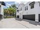 Exterior view of townhome features a gray garage door and mature landscaping at 3210 W Horatio St # 9, Tampa, FL 33609