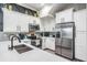 Well-lit kitchen featuring modern appliances, white cabinetry and gray tile backsplash at 3210 W Horatio St # 9, Tampa, FL 33609