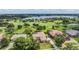 Beautiful aerial view of home on the golf course with lake in background on sunny day at 33744 Americana Ave, Dade City, FL 33525