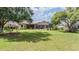 Expansive backyard with lush green lawn, screened-in lanai, and mature trees, perfect for outdoor enjoyment at 33744 Americana Ave, Dade City, FL 33525