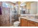 Bathroom featuring tiled walk-in shower, marble countertops, vanity, and decorative mirror at 33744 Americana Ave, Dade City, FL 33525