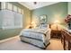 Charming bedroom with soft green walls, complemented by elegant floral bedding and classic furnishings at 33744 Americana Ave, Dade City, FL 33525