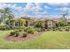 Beautiful single-story home featuring stone accents, a tile roof, and lush landscaping at 33744 Americana Ave, Dade City, FL 33525