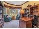 Elegant office space with a large wooden desk, built-in bookshelves, and comfortable seating area at 33744 Americana Ave, Dade City, FL 33525