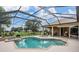 Screened-in pool area features in-ground pool, spa, and patio furniture perfect for outdoor relaxation at 33744 Americana Ave, Dade City, FL 33525