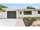 Charming single-story home with modern black garage door and stone walkway at 3381 19Th Sw Pl, Largo, FL 33774