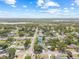 This aerial view shows a neighborhood with lush green trees, quaint homes, and a distant view of a lake at 3502 King Richard Ct, Seffner, FL 33584