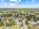 Expansive aerial shot of neighborhood homes surrounded by lush greenery and clear blue skies at 3502 King Richard Ct, Seffner, FL 33584