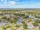 This aerial view shows a neighborhood with lush green trees, quaint homes, and a lovely blue sky at 3502 King Richard Ct, Seffner, FL 33584